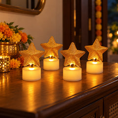 Four golden mesh star LED candles with white bases glow on a polished wooden surface, surrounded by festive decor.
