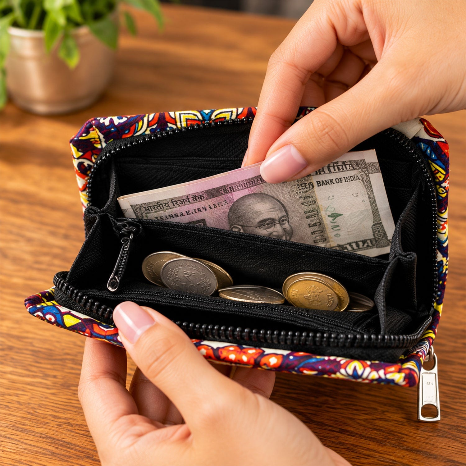 A hand places a banknote into an open, colorful fabric coin purse with a zipper closure and several coins inside.