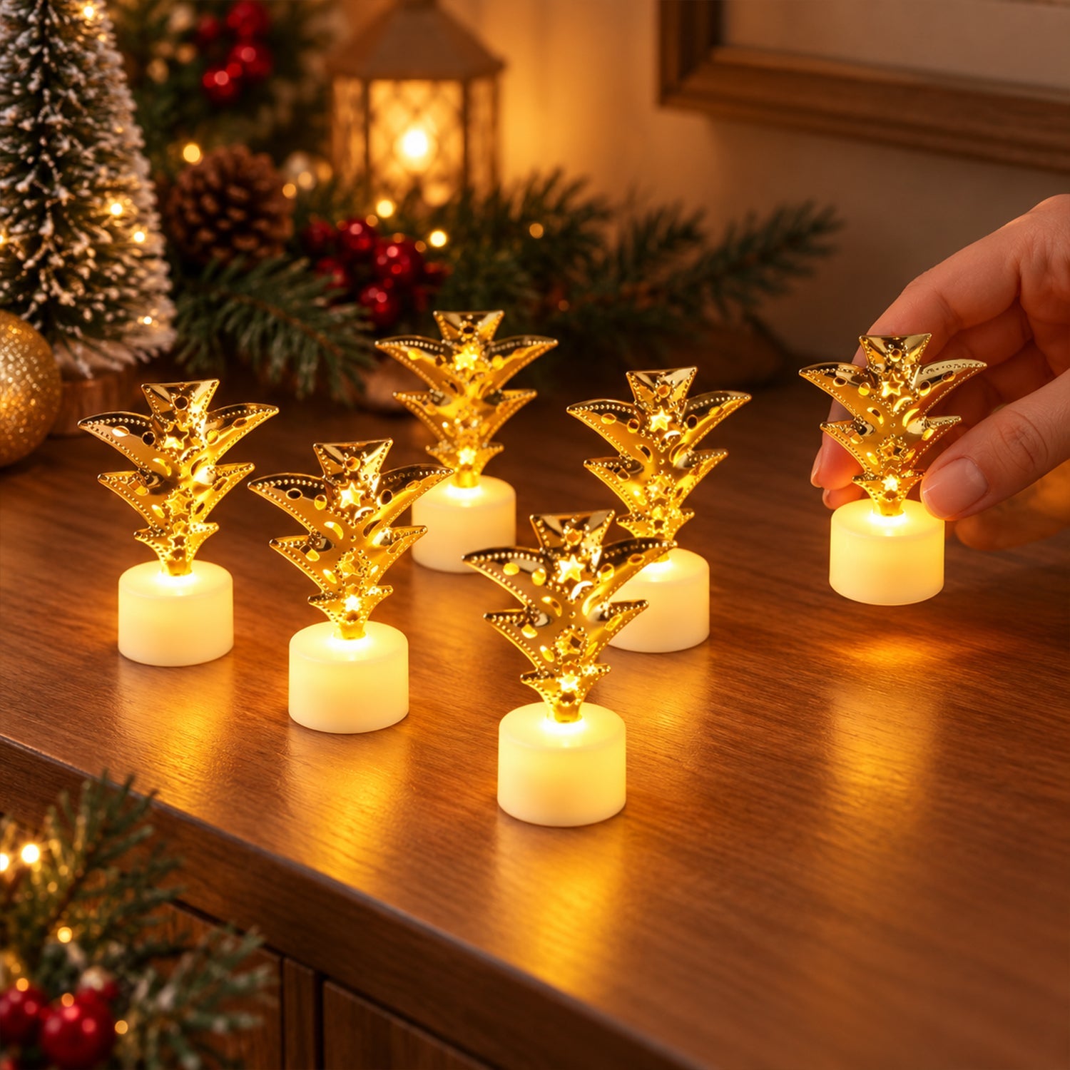 Seven golden pineapple LED tealights on a wooden surface with a hand reaching for one.