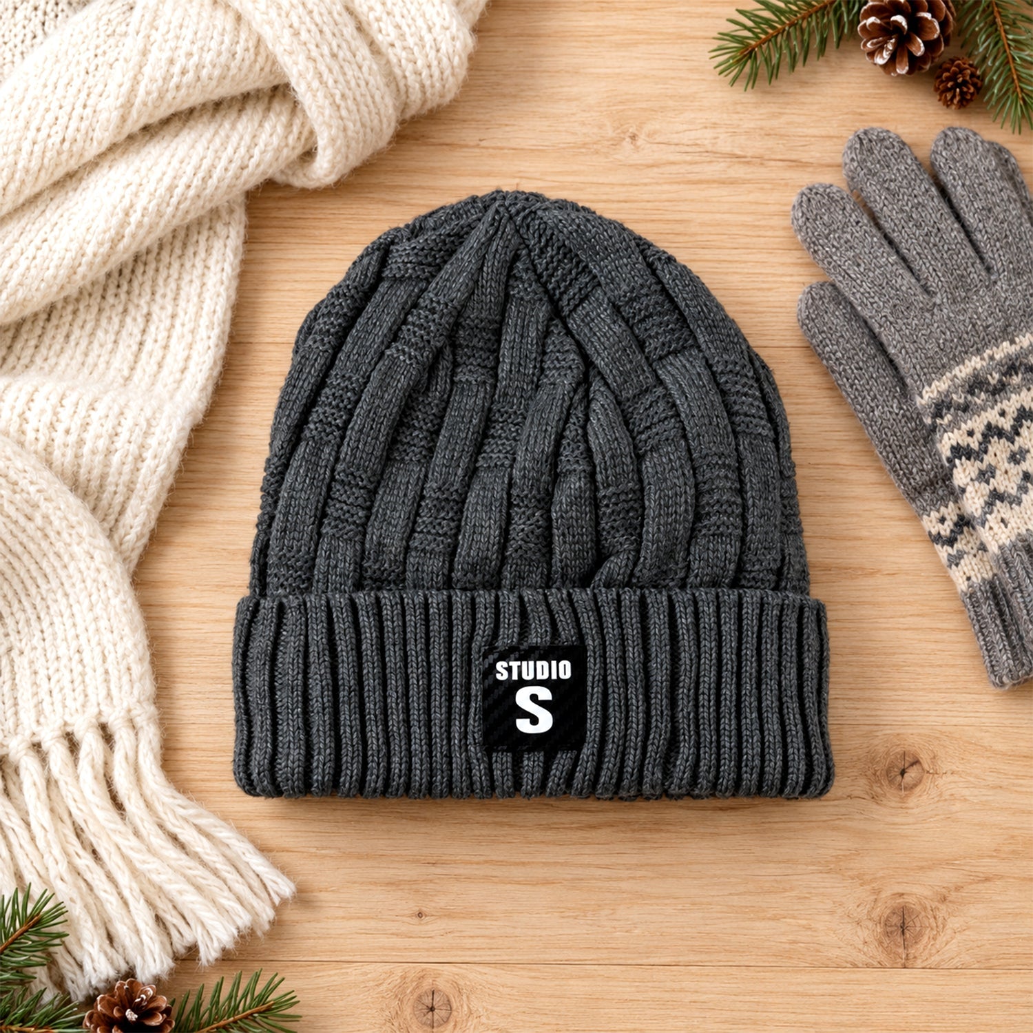 A dark grey cable knit beanie with a ribbed cuff and a black