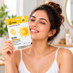 A smiling woman winks while holding the de-tan sheet mask package next to her face in a bathroom setting.