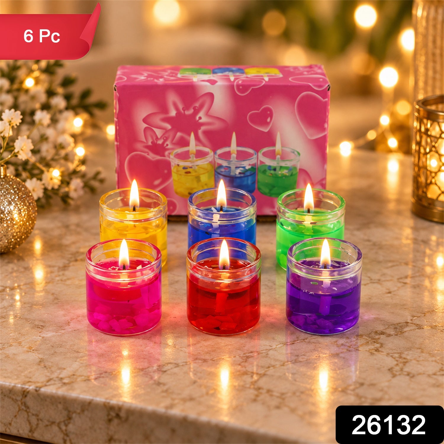 Six lit gel candles in glass jars, in yellow, blue, green, pink, red, and purple, arranged around a pink box. â€“ view 2
