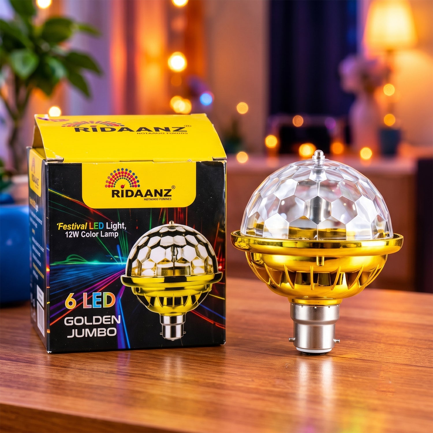 A gold and clear disco bulb with a B22 base sits next to its yellow and black packaging on a wooden table.