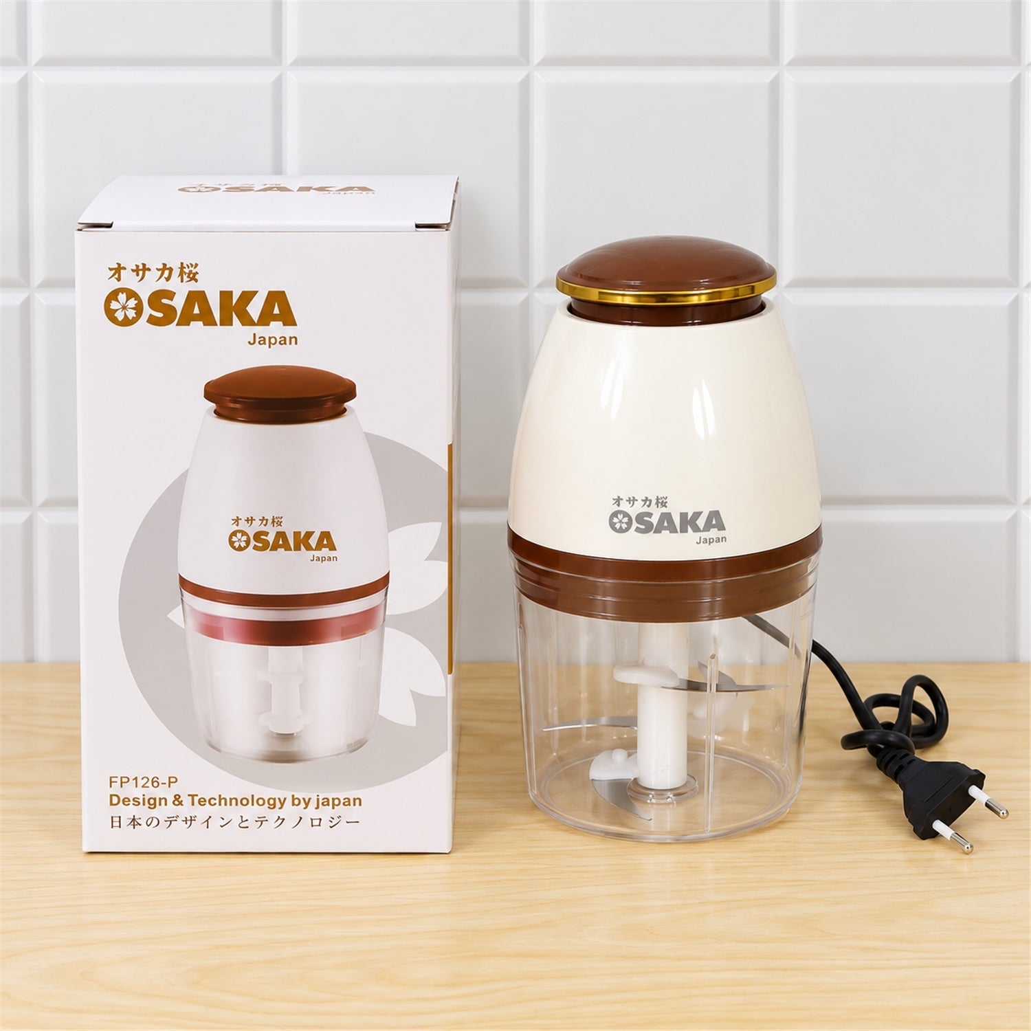 A white and brown electric chopper sits next to its product box, featuring the brand logo and design details, on a wooden