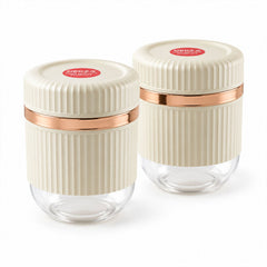 Two matching cream and clear ribbed containers with rose gold bands, lids closed, displayed against a plain white background.