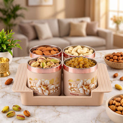 Four beige floral containers with rose gold lids, filled with various nuts, on a matching tray on a marble counter.