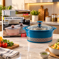 A teal insulated casserole dish with a clear lid and copper-colored knob, next to its product box.
