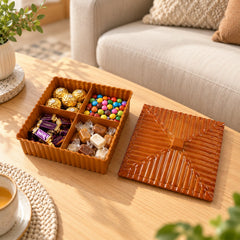 Brown four-compartment dry fruit and snack box with a ribbed lid, filled with assorted chocolates and candies.