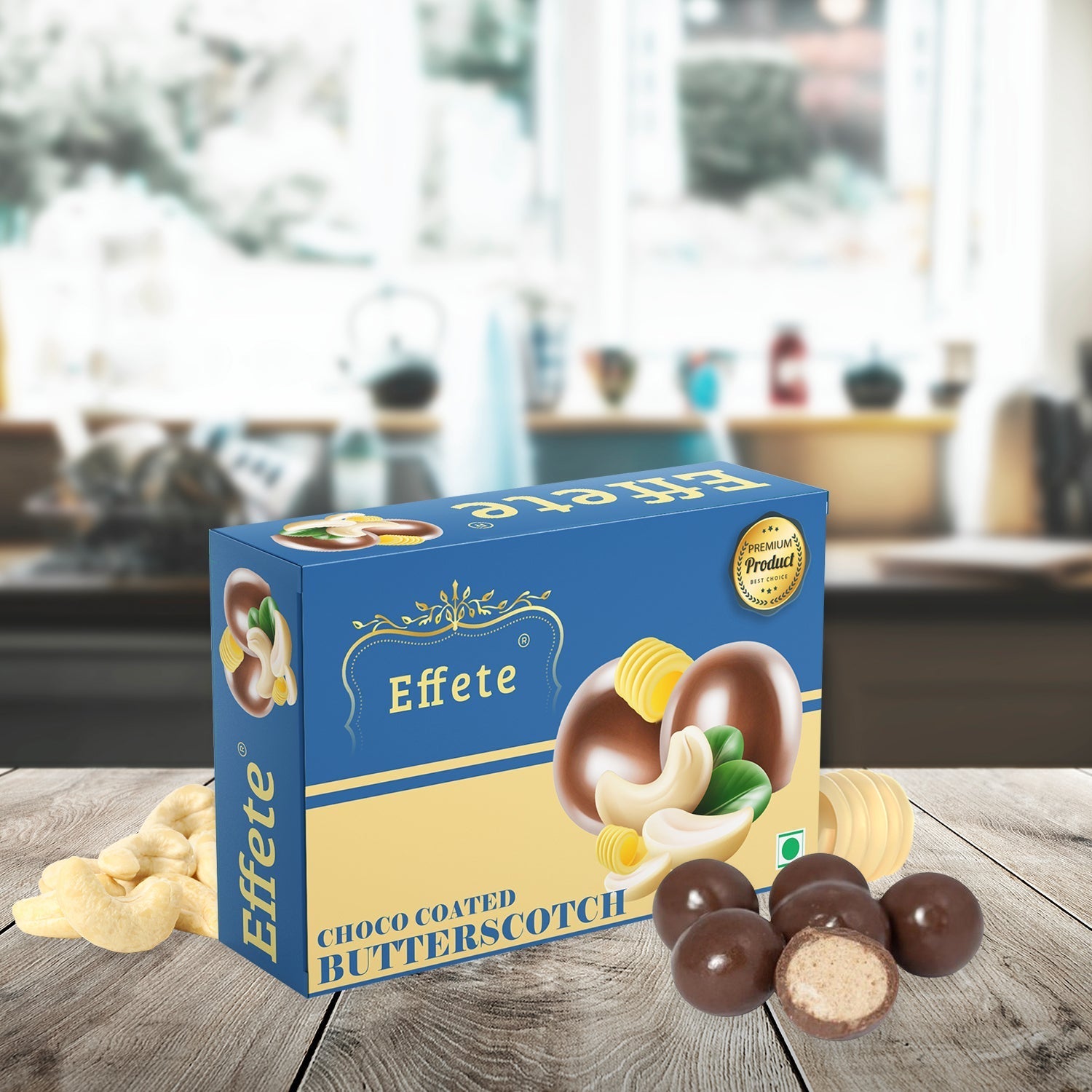 Blue and beige box of Effete Choco Coated Butterscotch, with cashews and chocolate balls on a wooden table.