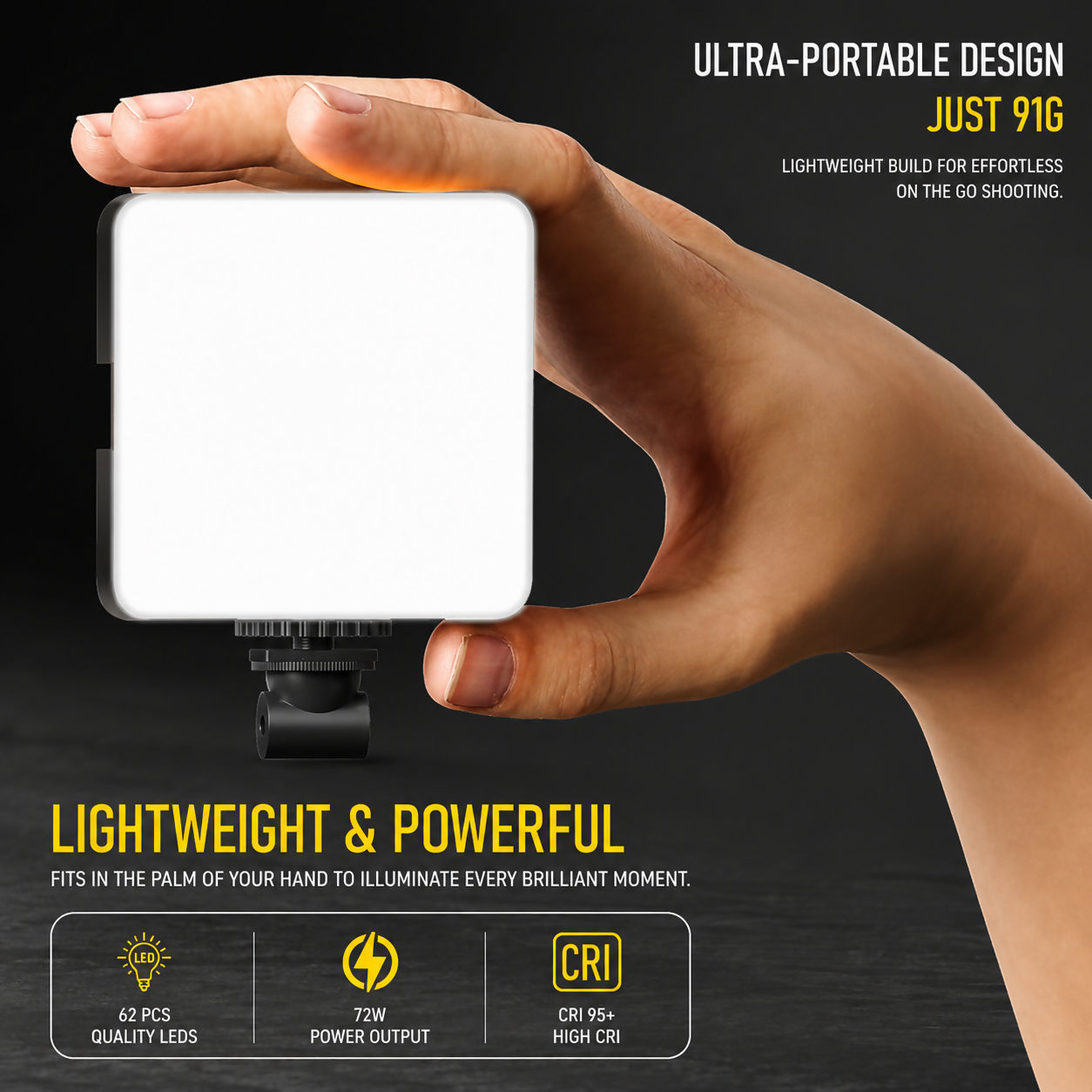 A hand holding a small, illuminated square LED video light with a white diffuser, against a dark background.