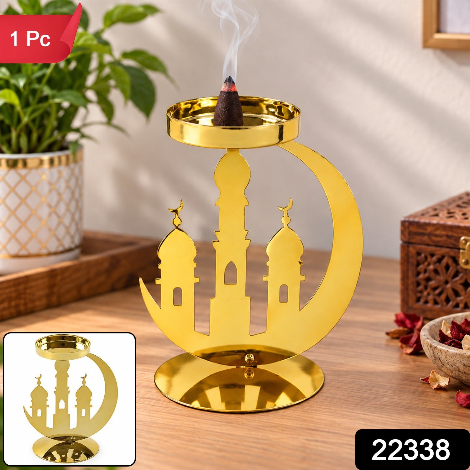 A golden metal incense holder with a crescent moon and mosque design, holding a burning dhoop cone on a wooden table, with a