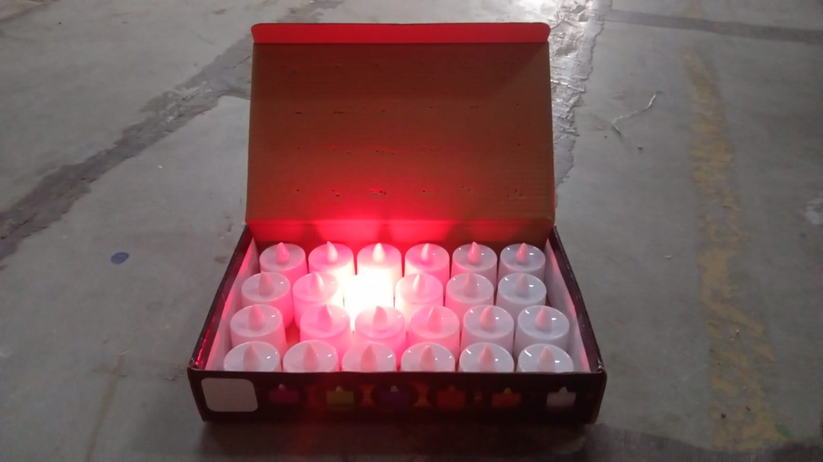 Red LED flameless tealight candles glowing on a decorative surface