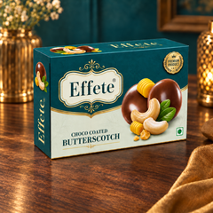 Effete Choco Coated Butterscotch box on a wooden table with blurred decorative elements in the background.