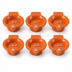 Six identical orange diyas, each with two silver sensors and a clear LED lens, are arranged on a white surface.