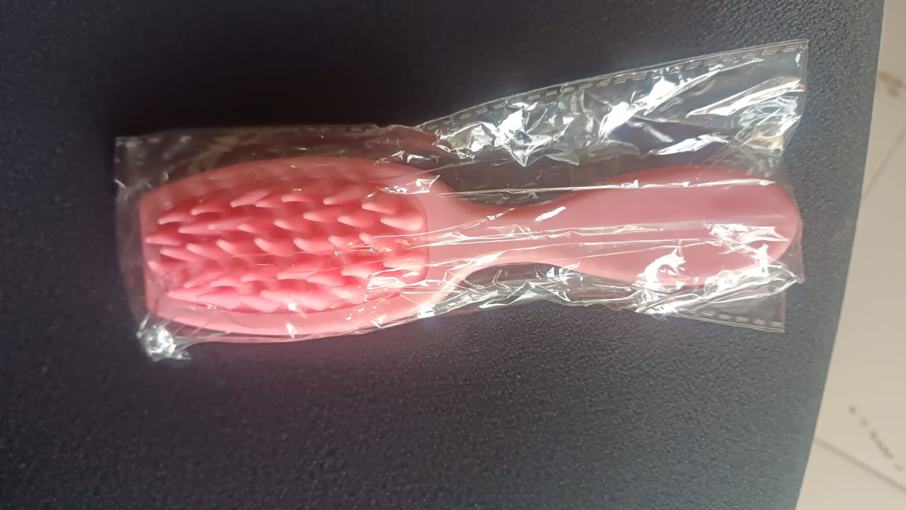 Person using silicone scalp massager on hair during shampoo