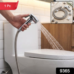 A hand holds a chrome bidet sprayer, spraying water towards a white toilet in a tiled bathroom, with a red "1 Pc" label.