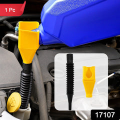 Using the flexible plastic funnel to pour oil into a car engine.