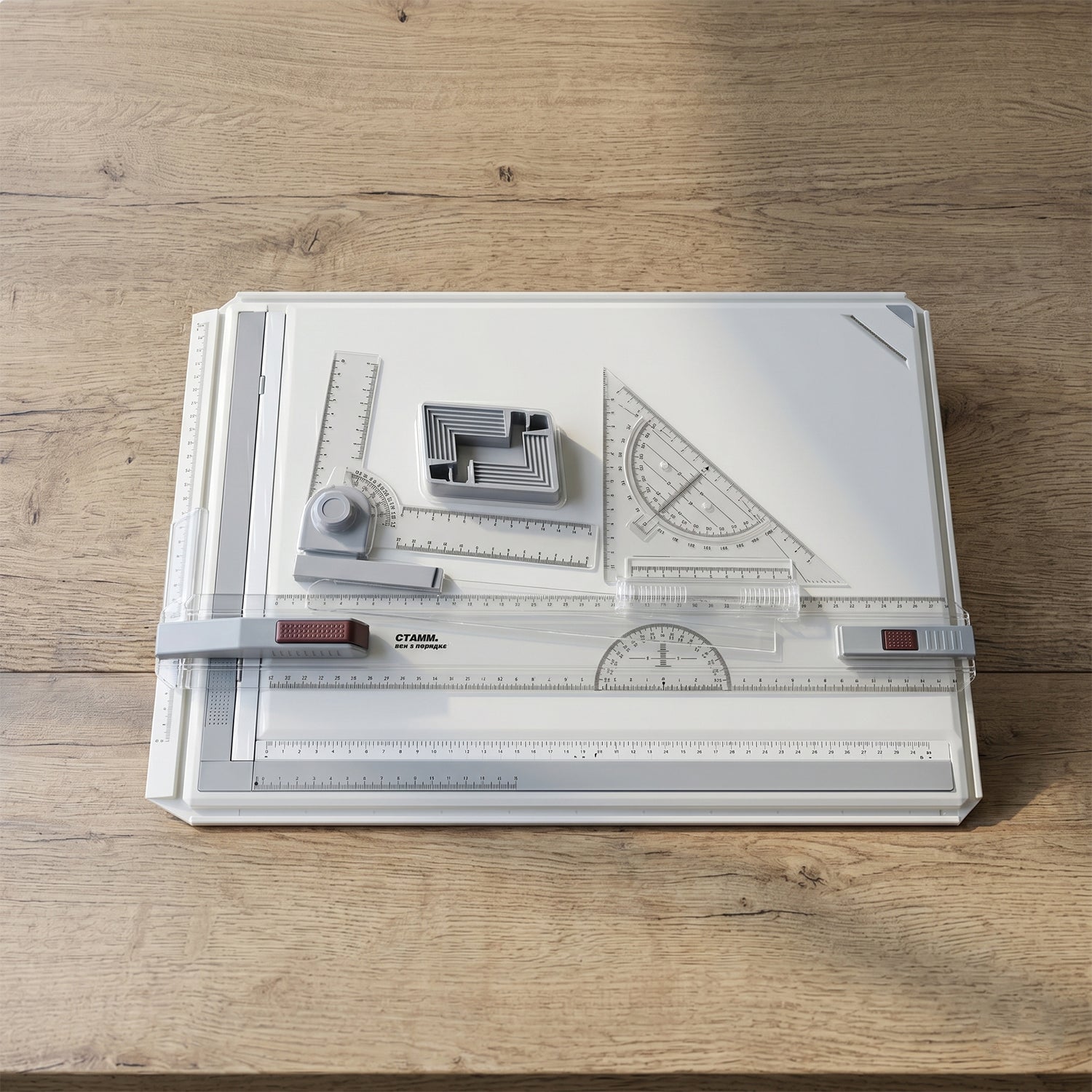 A white A3 drawing board with clear rulers and gray measurement tools, resting on a light wooden surface.