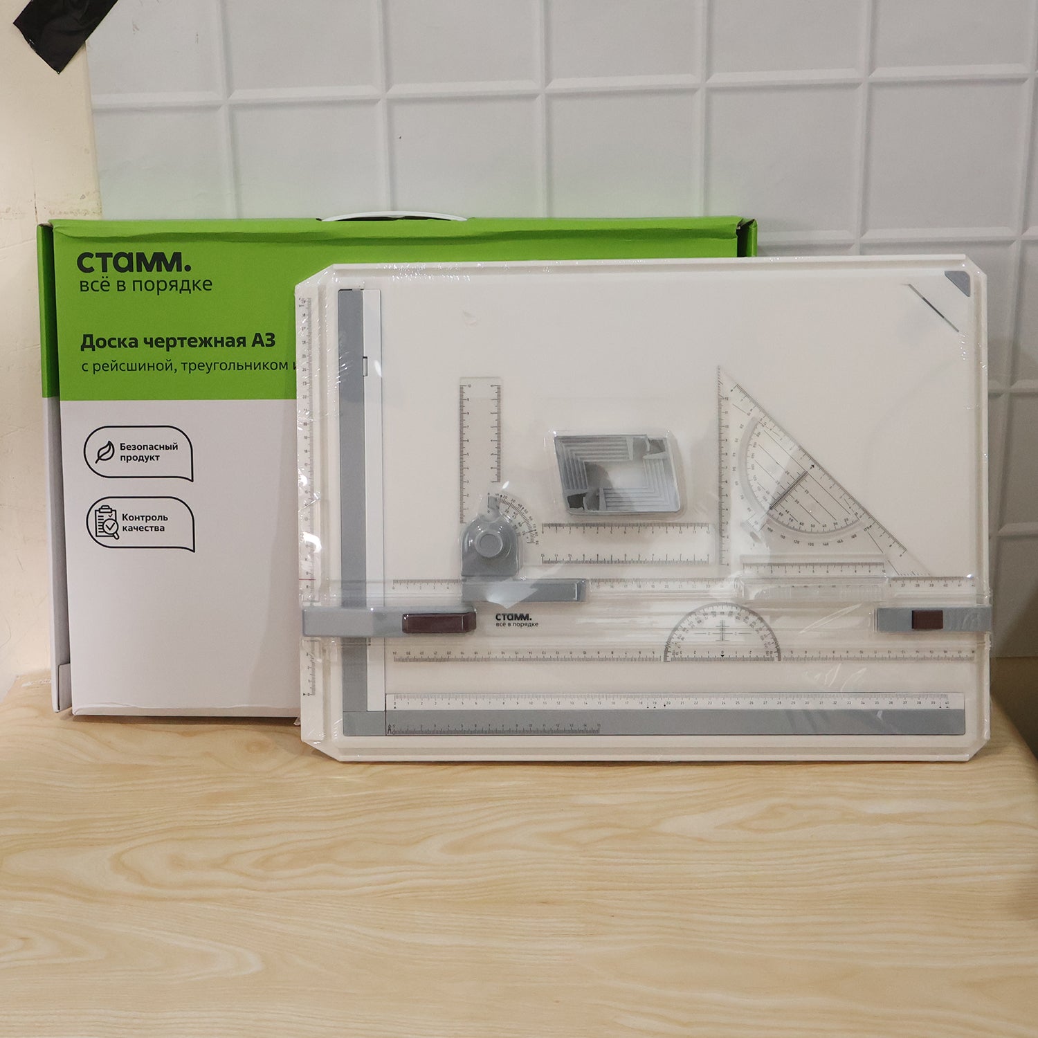 A white A3 drawing board with rulers and tools sits next to its green and white product packaging box.