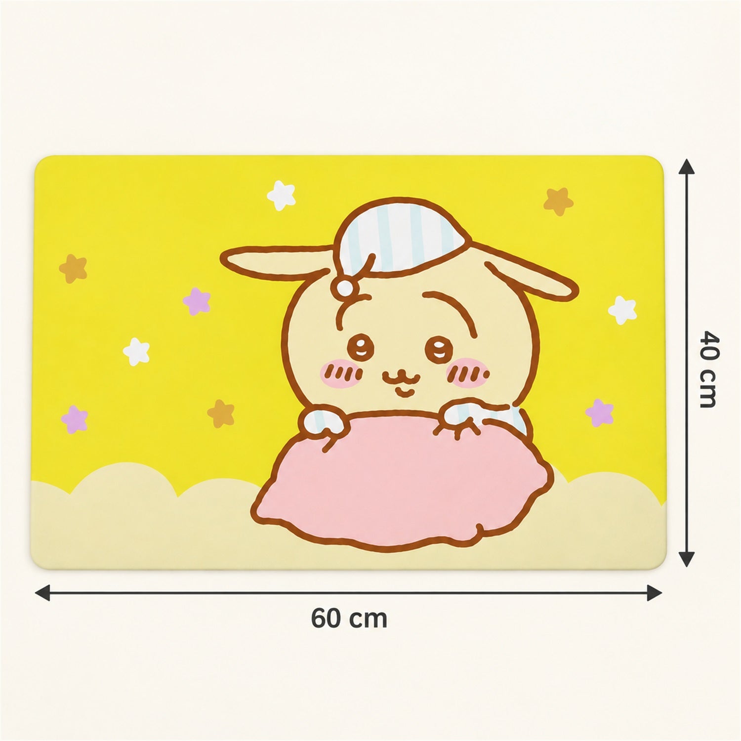A yellow bath mat with a cartoon bunny design shows its dimensions: 60 cm wide and 40 cm tall.
