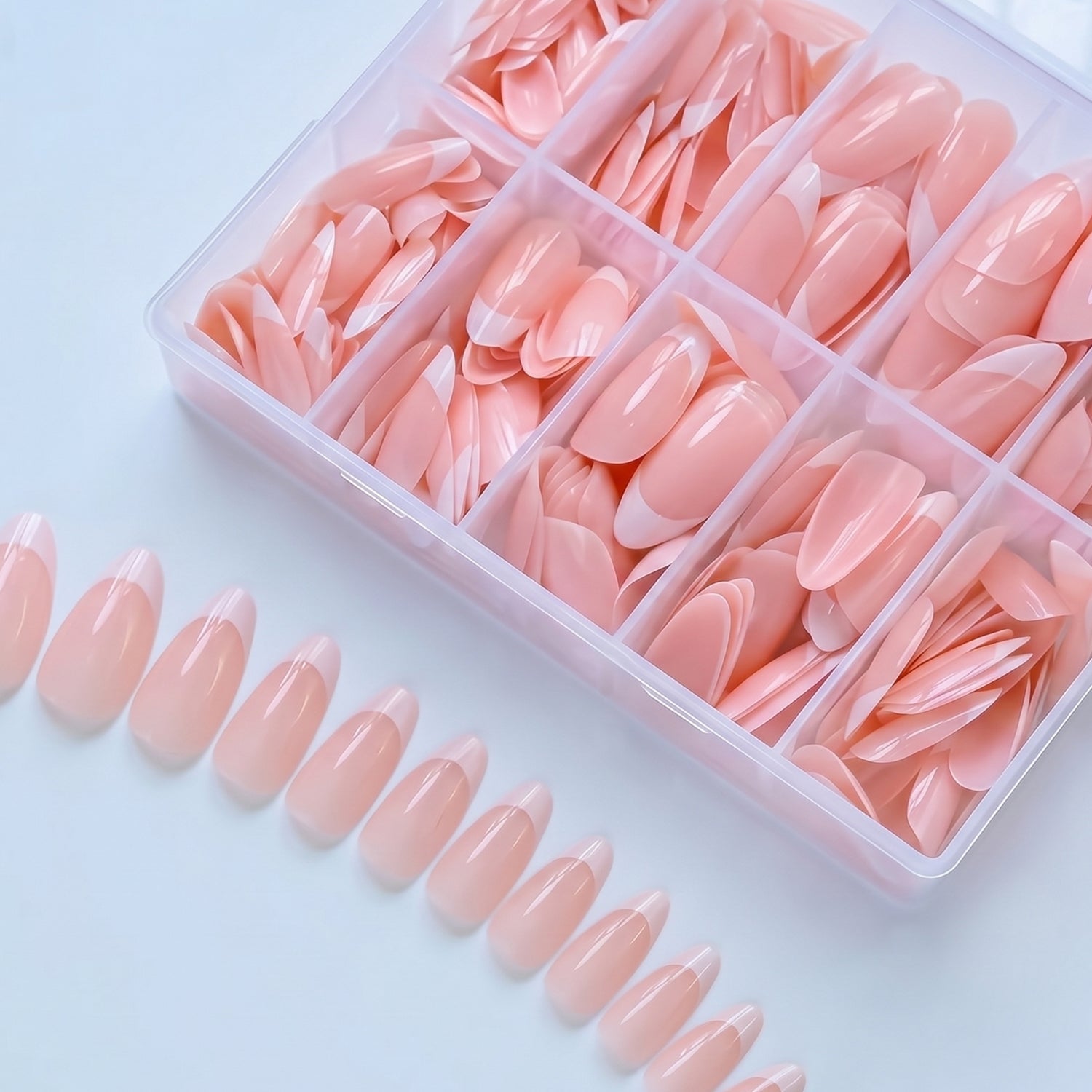 Artificial nail tips in various sizes laid out on a surface