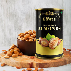 Black and gold tin of Effete Choco Coated Almonds on a wooden board, with a brown bowl of almonds.
