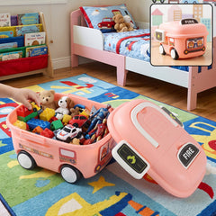 A child's hand reaches into a pink fire truck toy storage box filled with colorful toys on a rug in a bedroom.