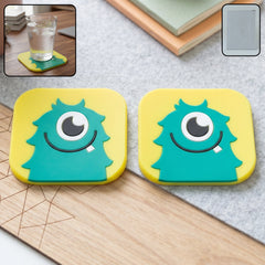 Cute cartoon monster silicone coaster set in yellow and teal colors for table protection.
