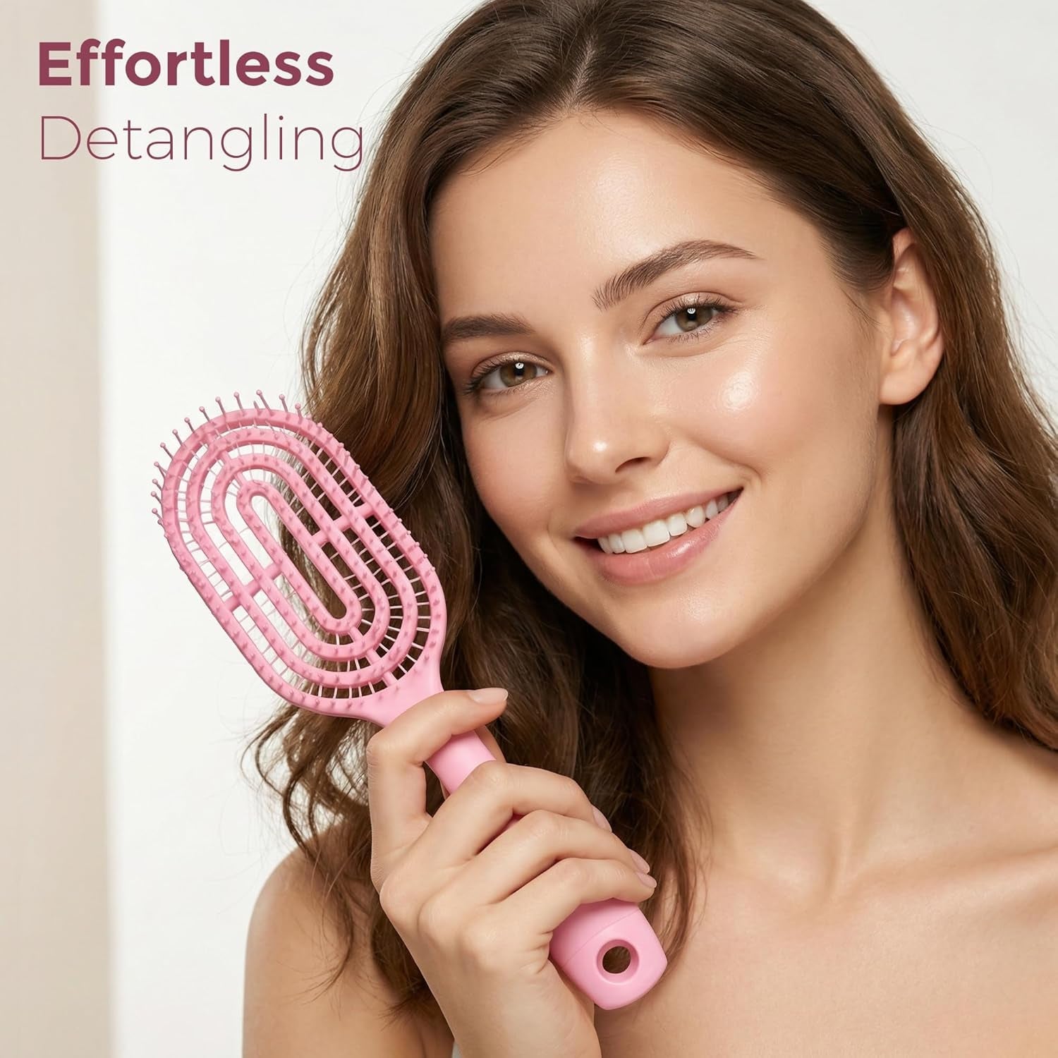 Person holding pink curved detangling hair brush