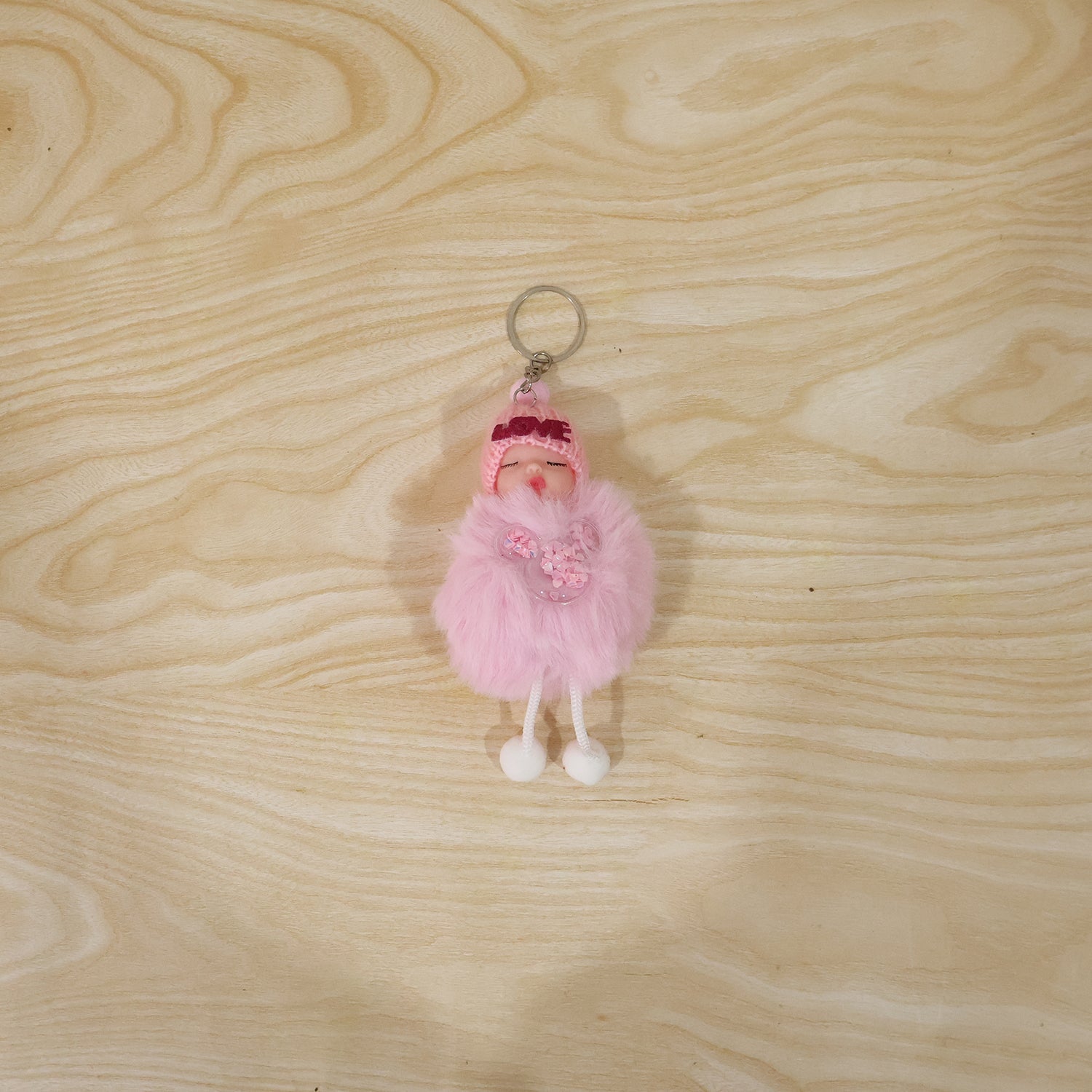 Cute doll plush keychain with soft fur ball hanging on a bag