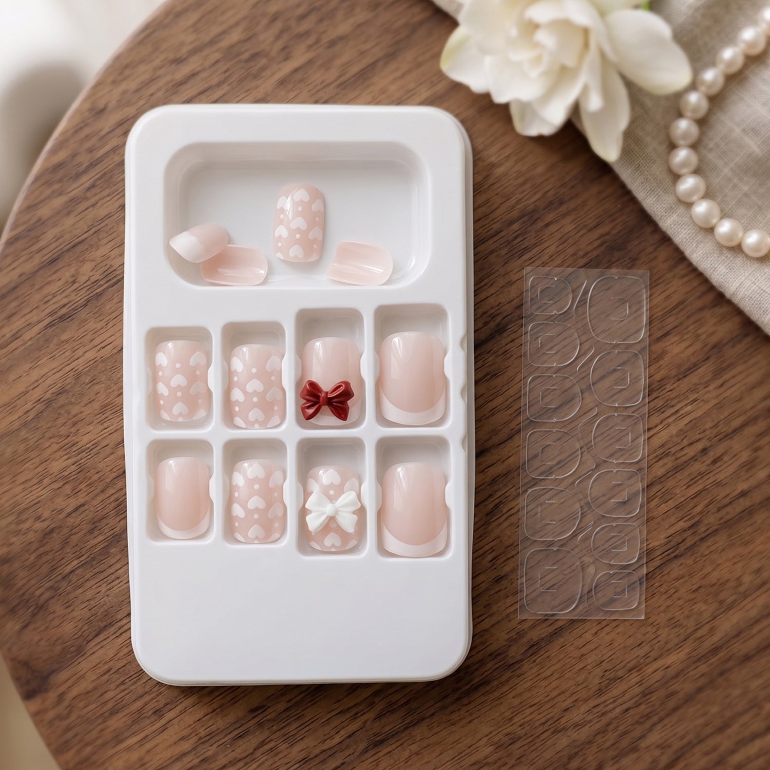Detailed view of the 3D floral elements and shimmering glitter on the artificial nail tips.