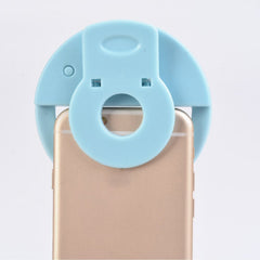 LED selfie ring light illuminating a phone for selfies