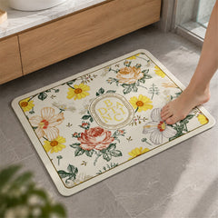 A single bare foot steps onto a rectangular bath mat with a vibrant floral pattern on a light background, placed on a grey