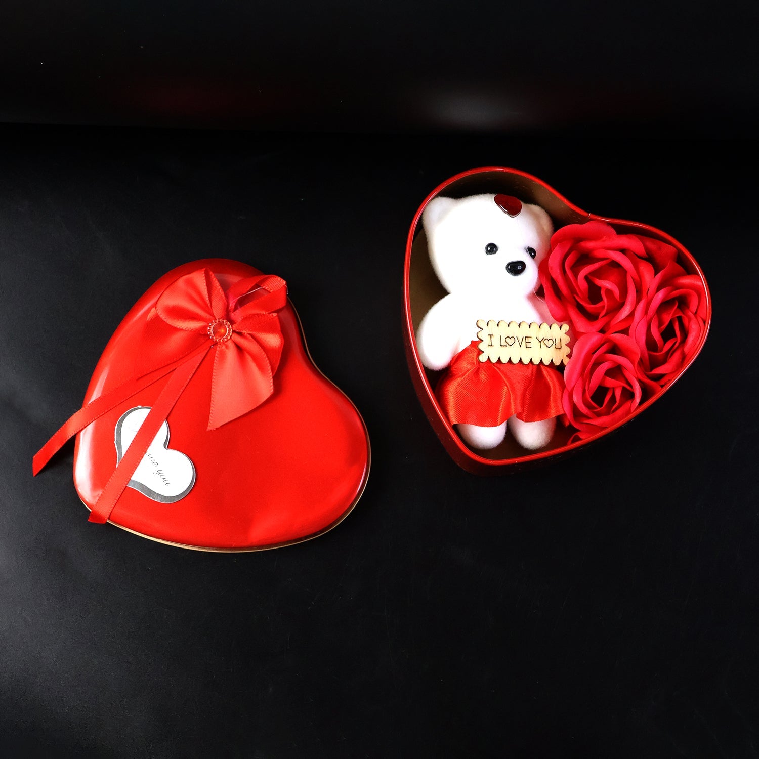 Top view of heart shaped gift box with teddy bear and roses