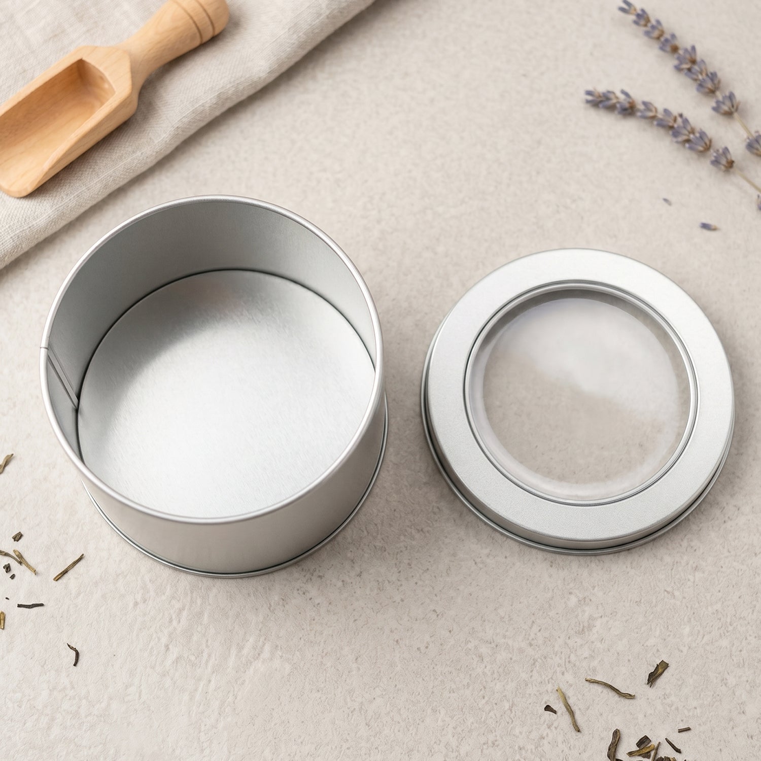 Elegant silver metal tin with clear lid for small item storage and gifting.