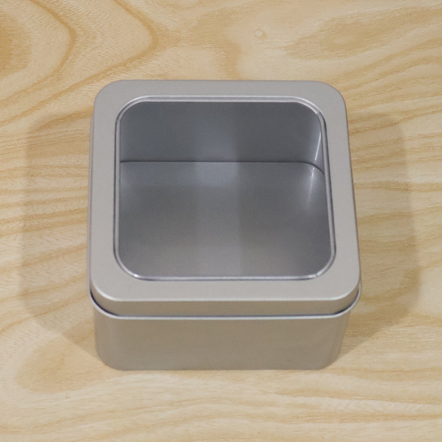Detail shot of metal storage tin box, highlighting sturdy construction and clear lid