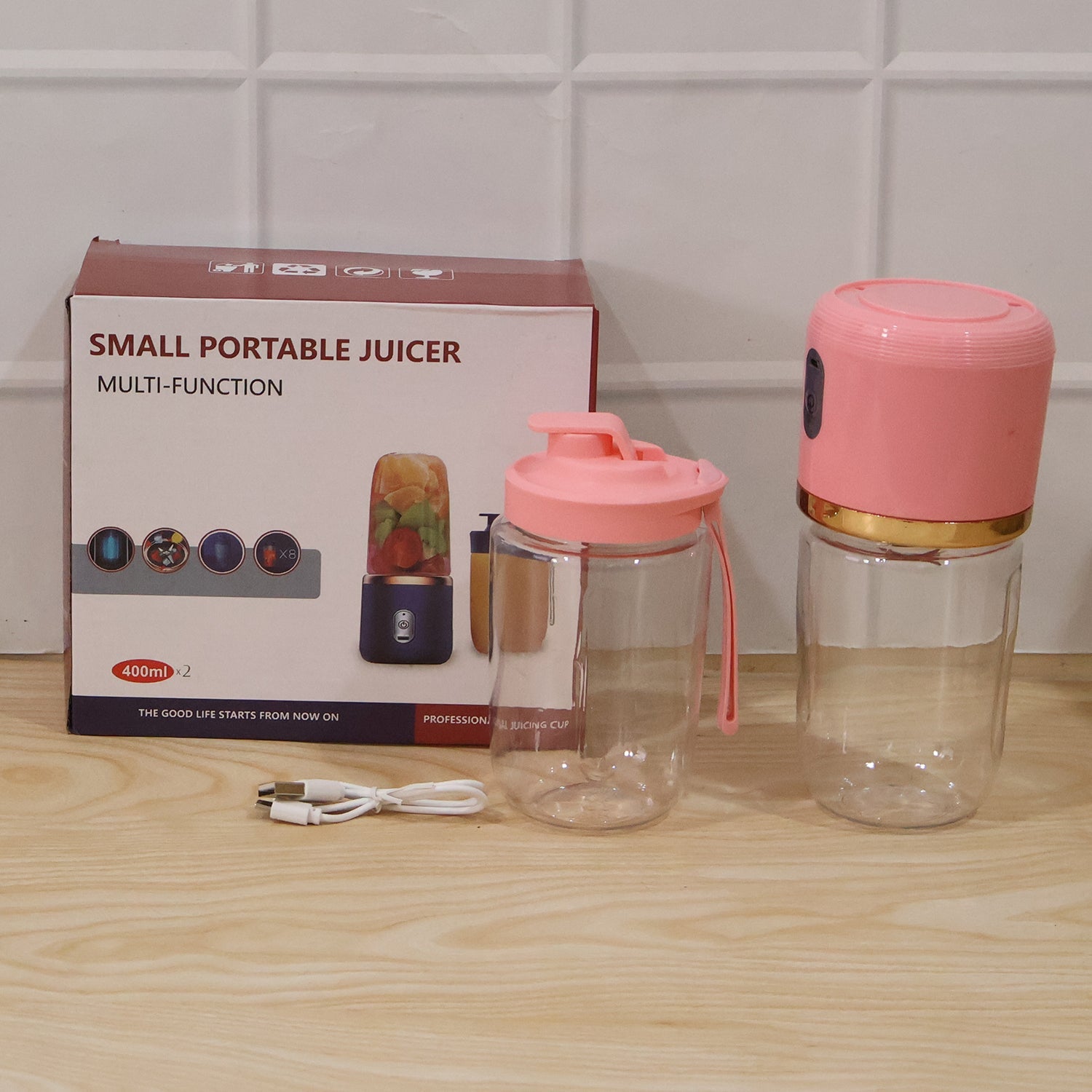 Pink portable juicer with cups designed for smoothies and shakes