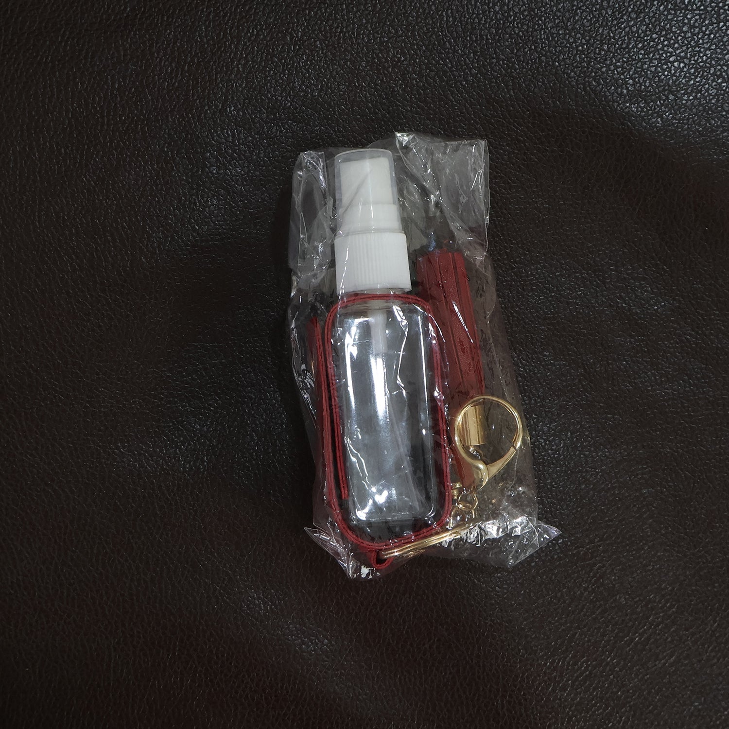 Person holding faux leather hand sanitizer holder keychain