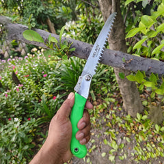Folding saw in action cutting wood, with non-slip handle visible