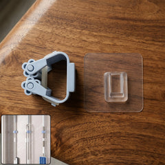 Self-adhesive broom mop holder in light blue grey color mounted on a wall.