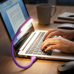 Flexible USB LED light plugged into laptop providing soft purple illumination
