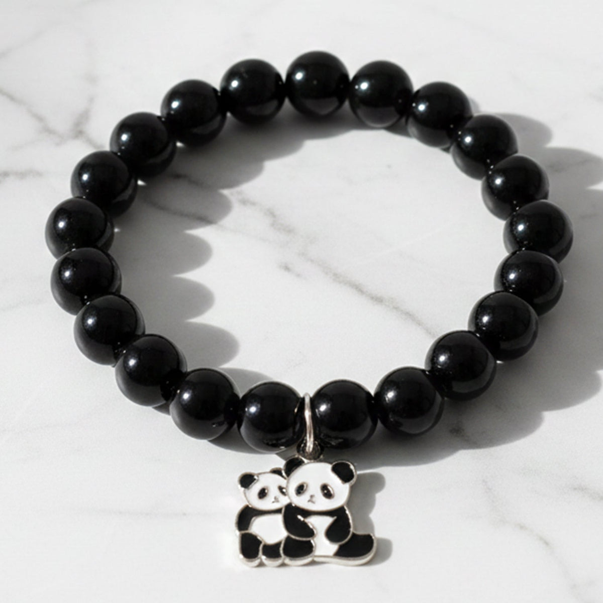 Black beaded stretch bracelet with panda charm on a white background