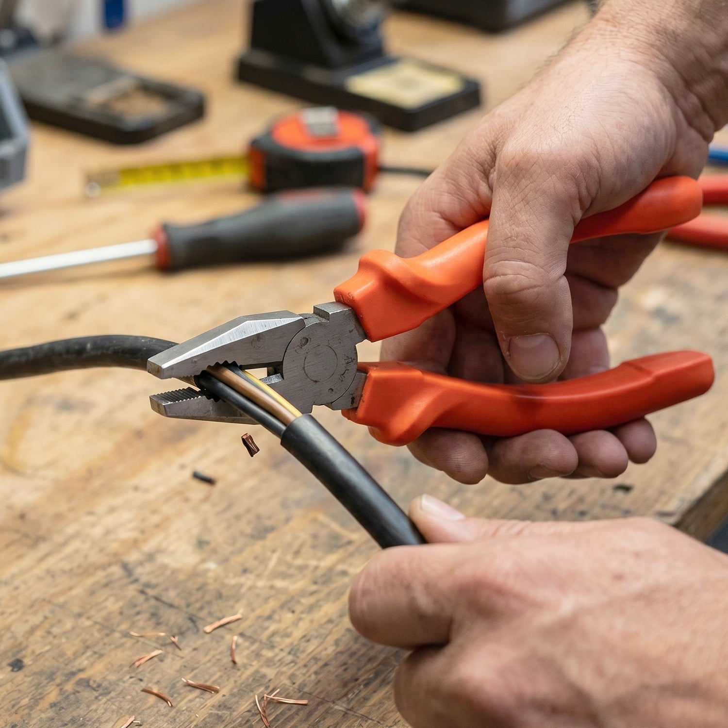 Electrical workshop scene with heavy-duty combination pliers in use