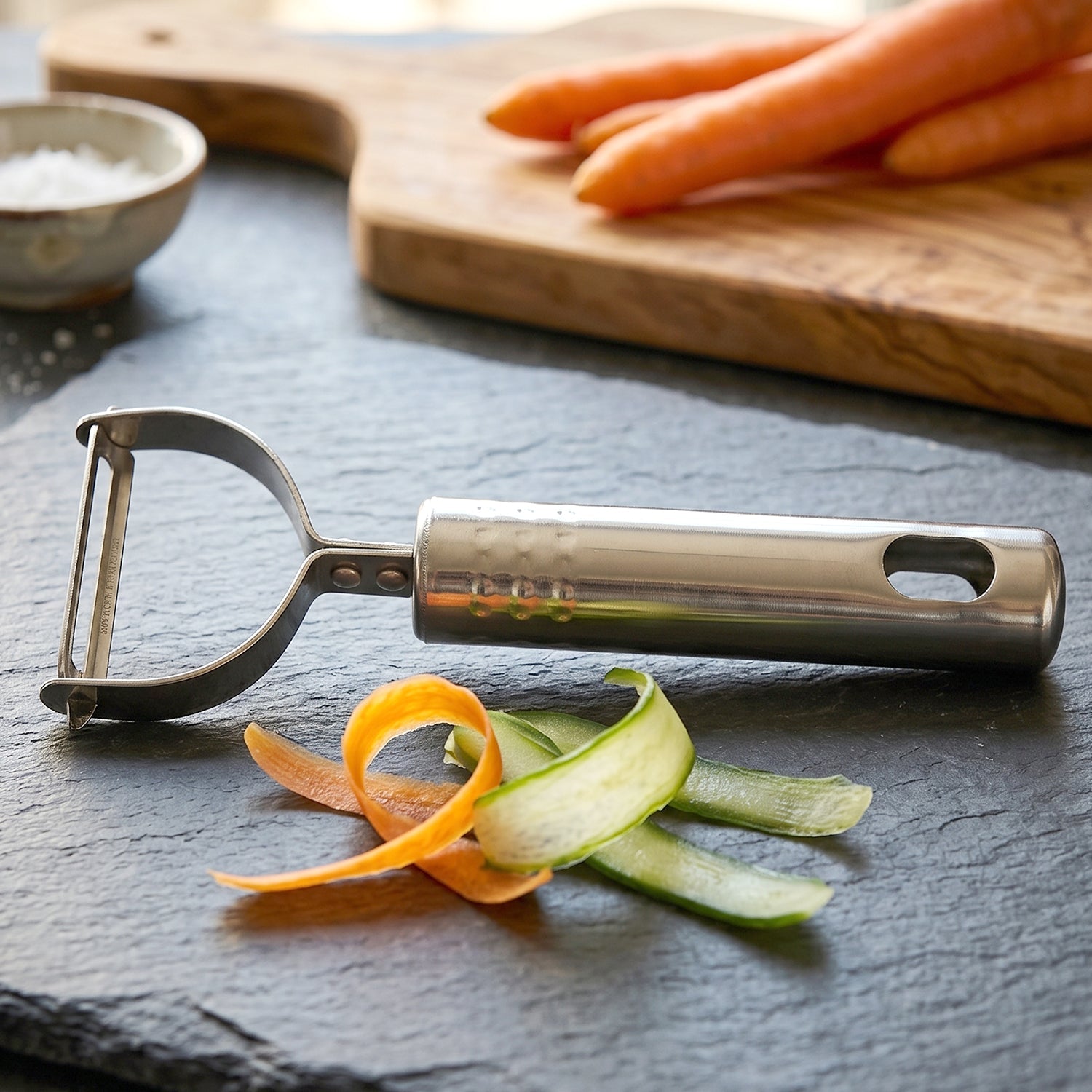 Peeler near sliced vegetables