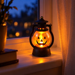 A single glowing pumpkin lantern sits on a window sill at dusk, casting a warm light beside a book.