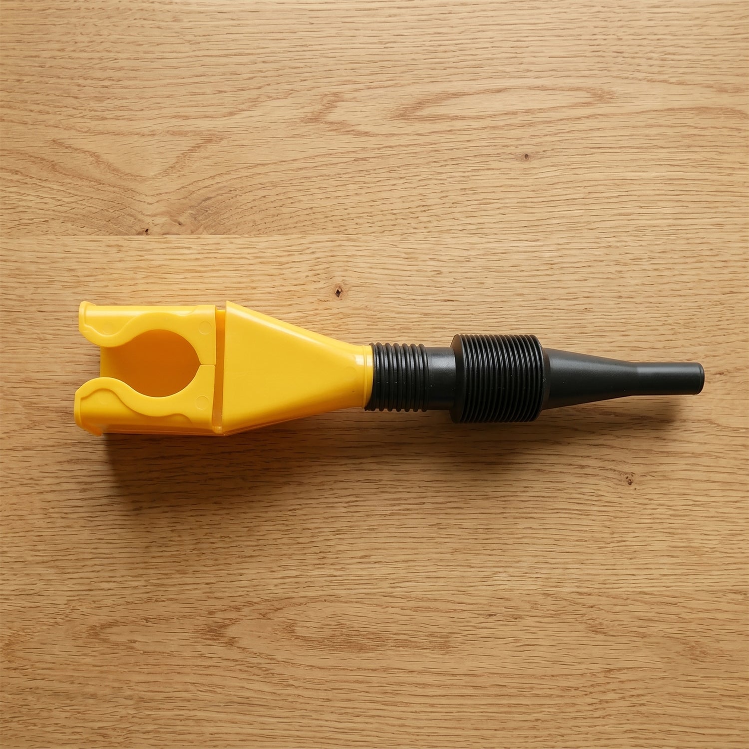 Detail view of the flexible plastic funnel's corrugated neck design.