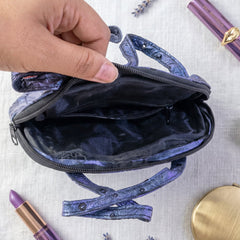 Close-up of mini handbag with top zipper and side pockets in metallic blue