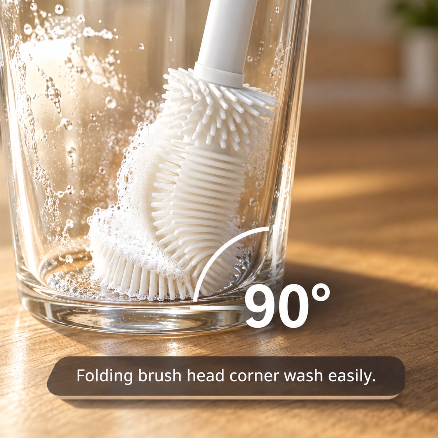 A white silicone brush head with suds cleaning the inside of a clear glass, demonstrating its 90-degree flexibility.