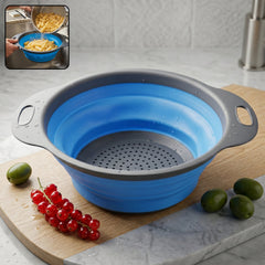 Blue collapsible silicone strainer with side handles for easy rinsing and draining.