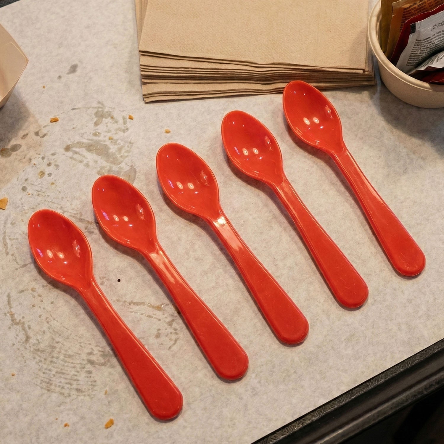 Person eating with a white plastic spoon from a plate